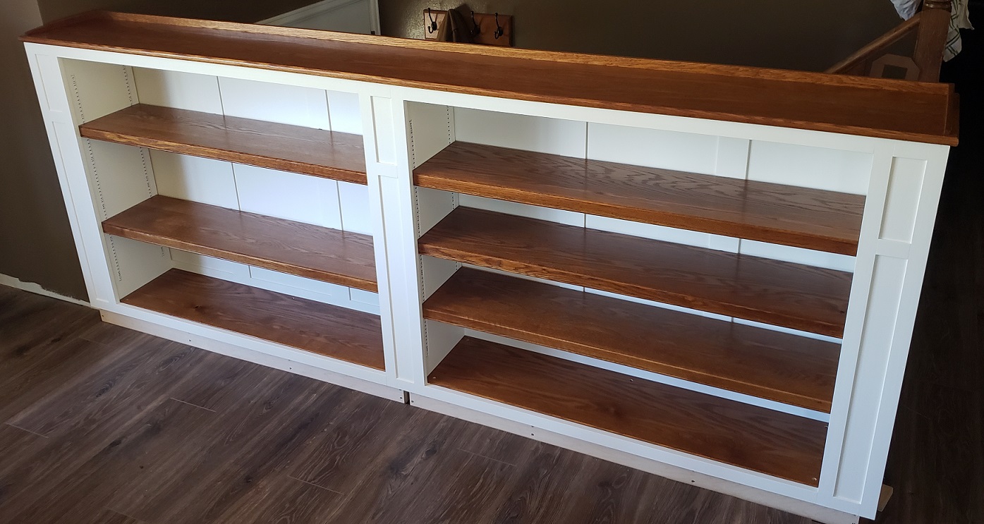 White and stained oak built in bookshelf in front of stairs daytime