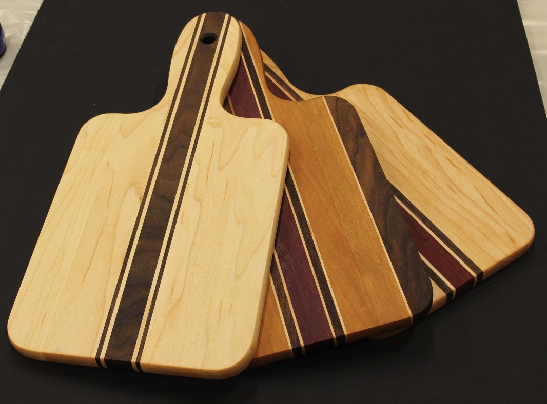 Three small charcuterie boards with handles black background