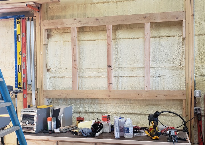 Support structure for post-frame construction building behind workbench