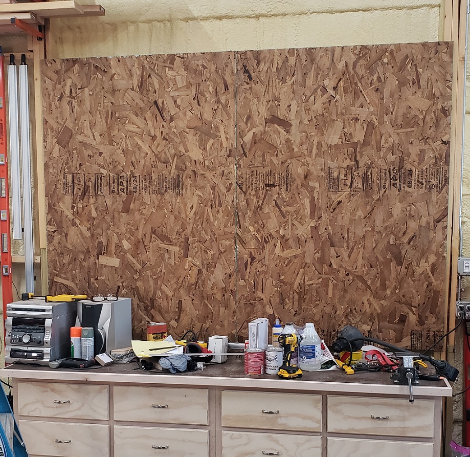 OSB panels mounted to wall behind workbench