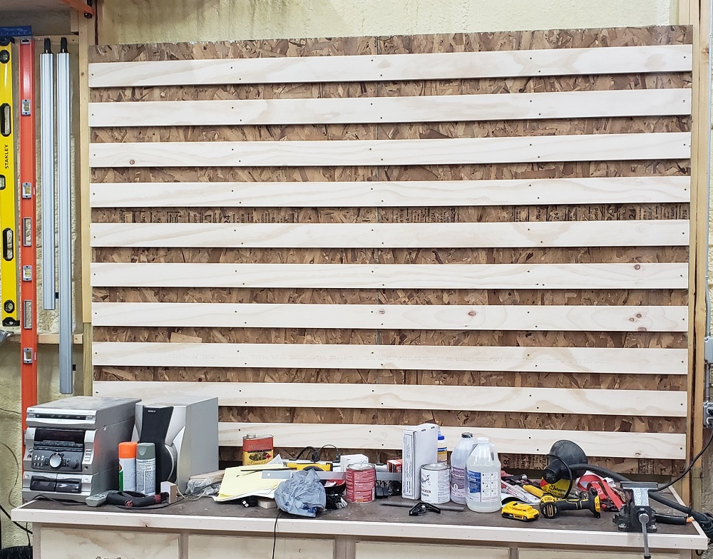 Plywood French cleats mounted to wall behind workbench