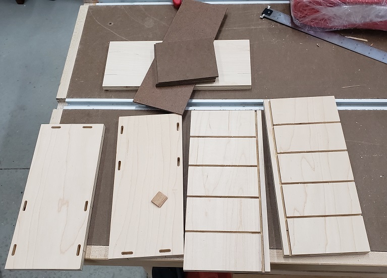 Plywood pieces with floating tenons cut sitting on workbench