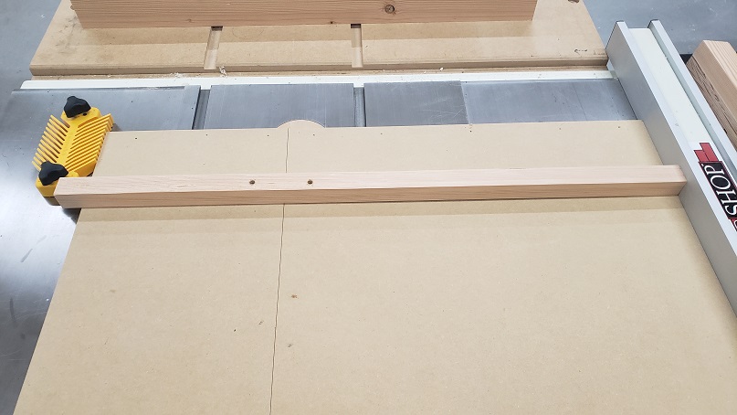 Board connecting two MDF panels held in place with a featherboard and tablesaw fence