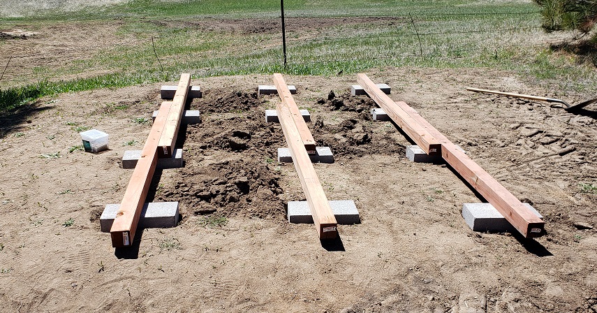 Four by four boards on cidner block caps dug into the ground