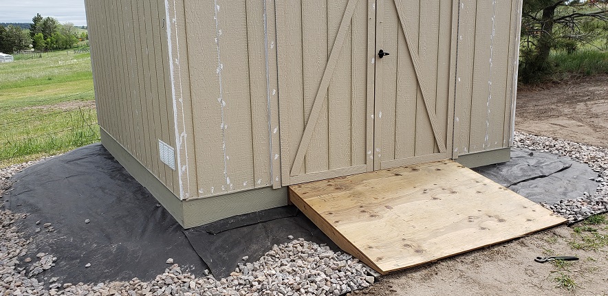 Unpainted shed with hardie board surround and plywood ramp