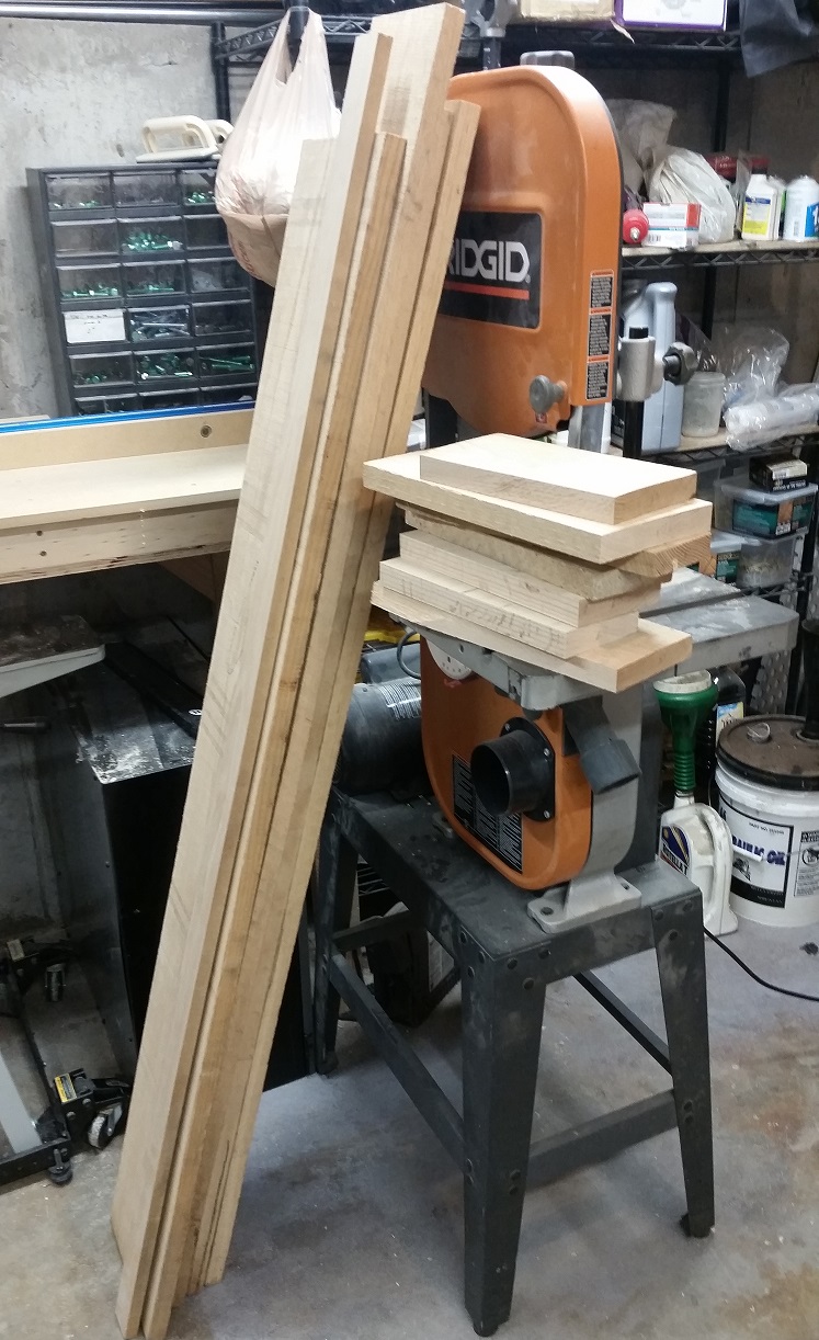 Rough oak boards resting against Ridgid bandsaw