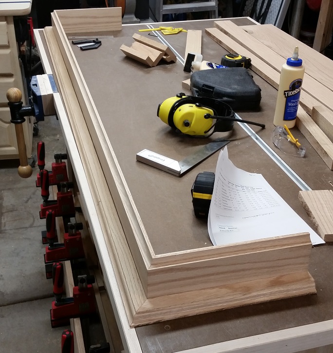 Routed oak board mock up for fireplace mantel on workbench
