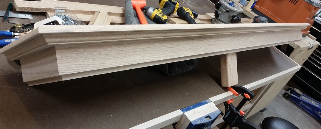 Top portion of oak fireplace mantel in progress on workbench