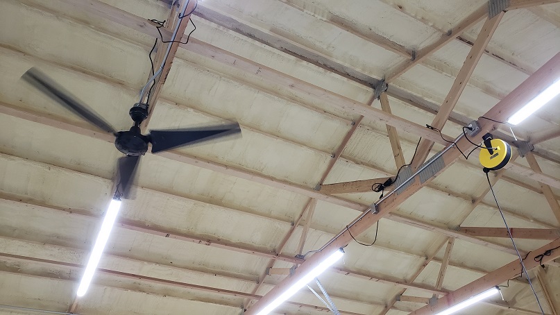 Black ceiling fan and LED shop lights in pole barn