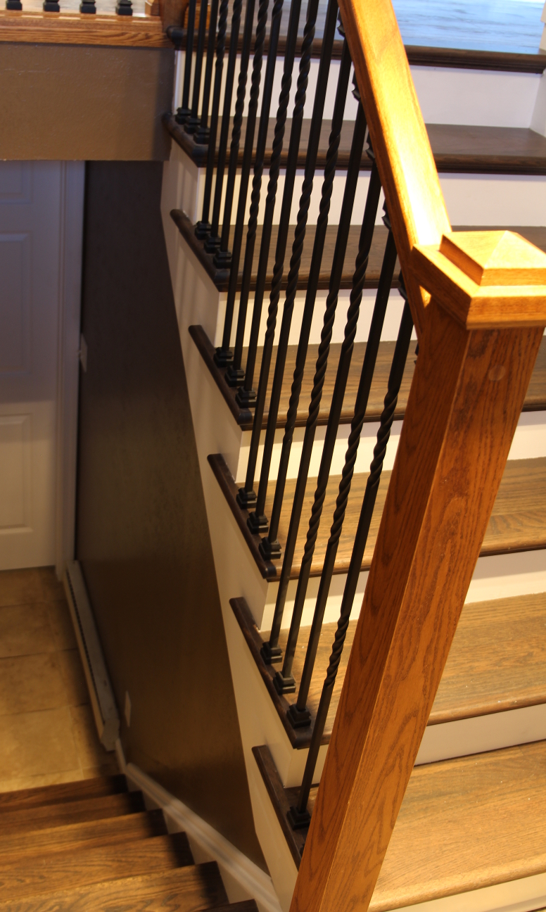 White stringer cover and stair riser covers with dark oak treads and metal ballusters