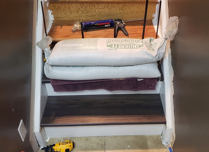 Gluing down stair tread cover with clamps and sandbags