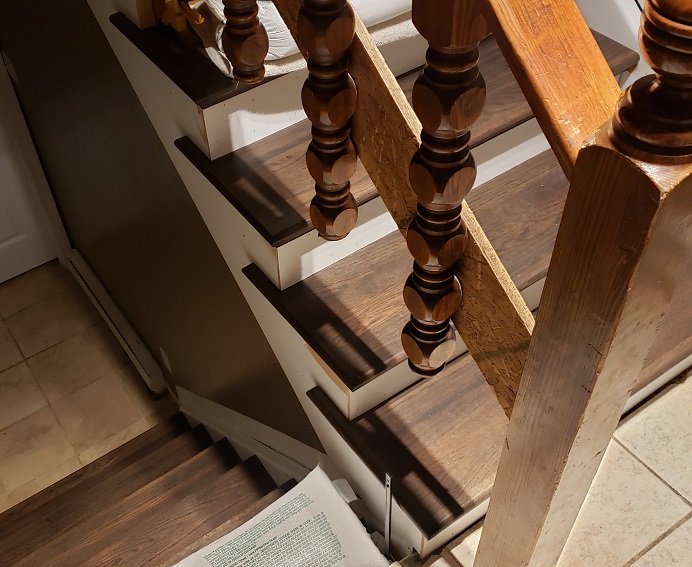 Dark oak stair tread covers with returns and white trim