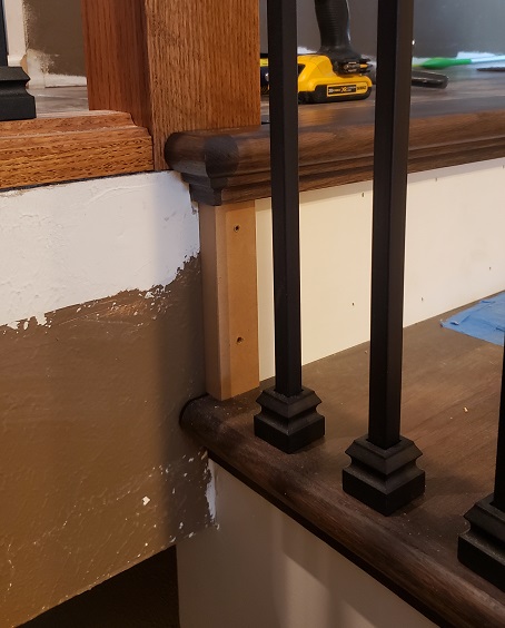 Stair riser trim with dark oak treads and metal ballusters