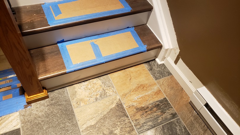 Stone look porcelain tile on stair landing with white trim and brown wall