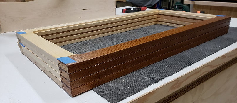 Stack of maple and oak drawer support frames on workbench