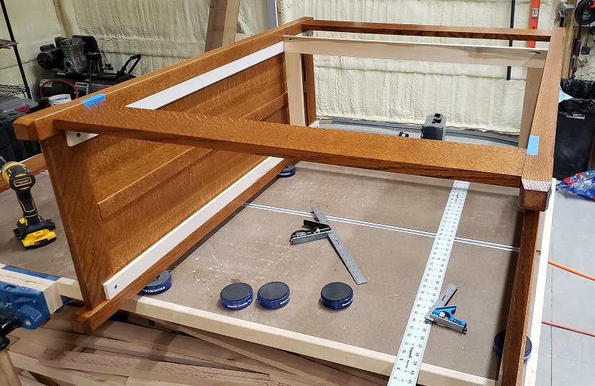 Oak dresser sides held with board on workbench