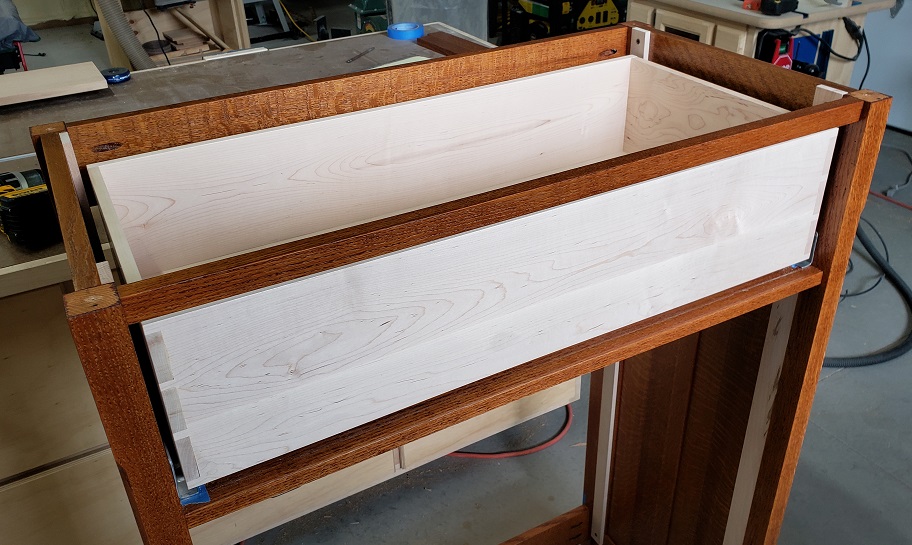 Partially assembled oak dresser with maple drawer box