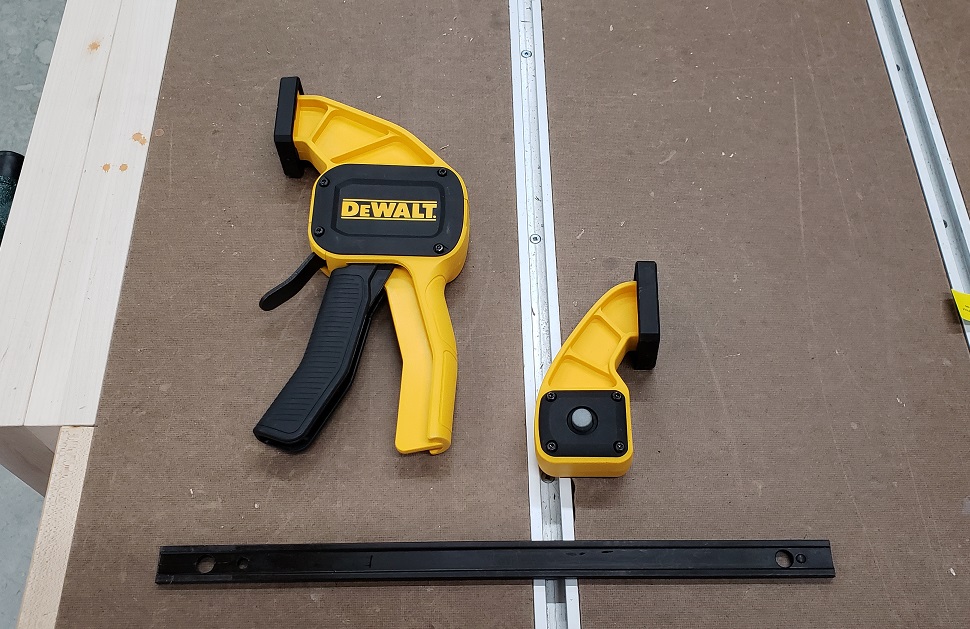 Disassembled DeWalt quick clamp on workbench with t-track