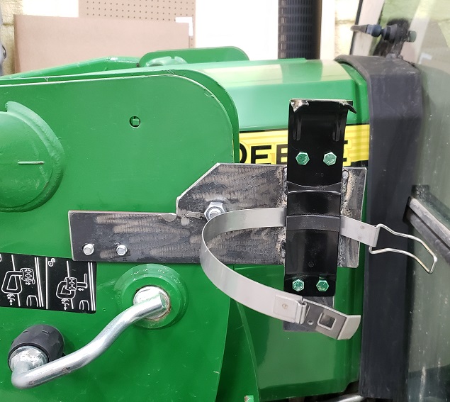 Bare metal extinguisher mount on a John Deere H240 loader