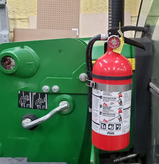 Fire extinguisher mounted to a John Deere H240 loader on a 5055E tractor